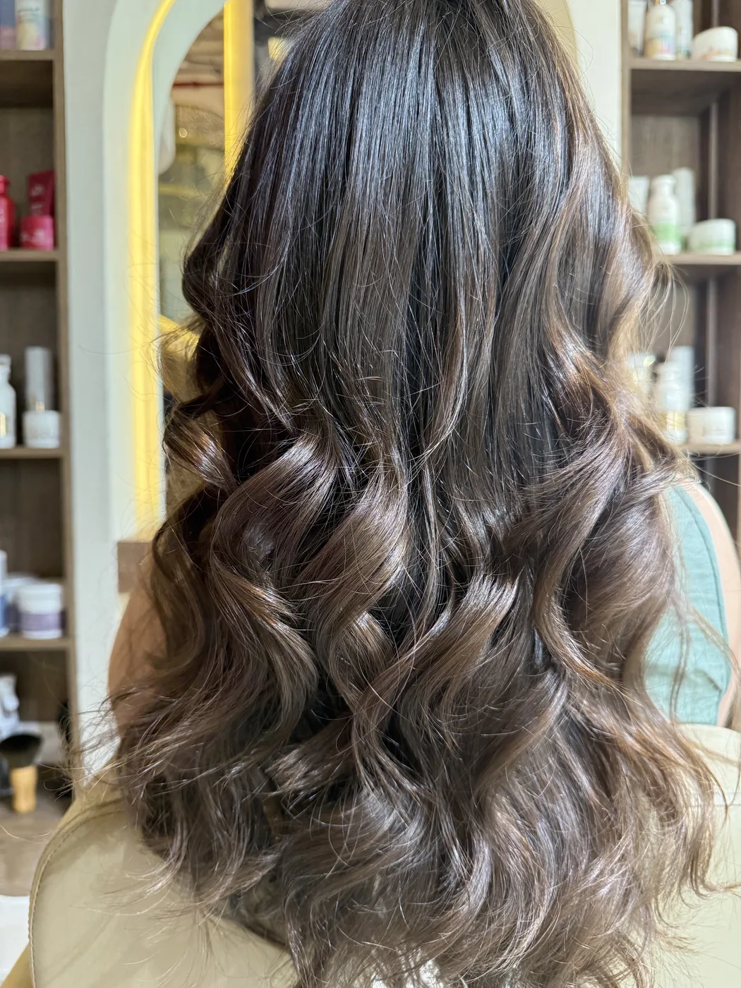Back view of long dark brown hair in loose waves with caramel highlights