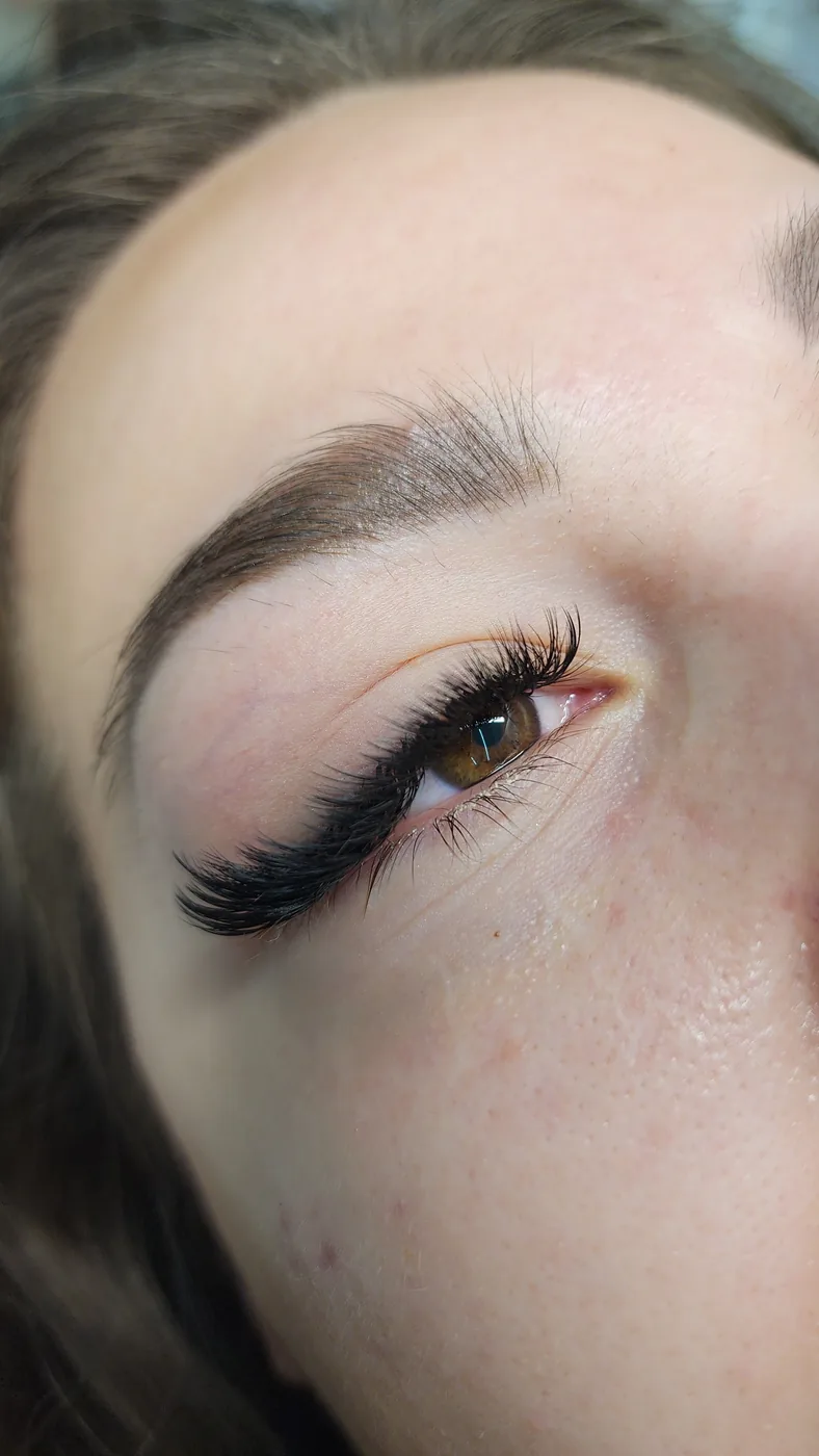 Extreme close-up of one eye with long black volume lash extensions