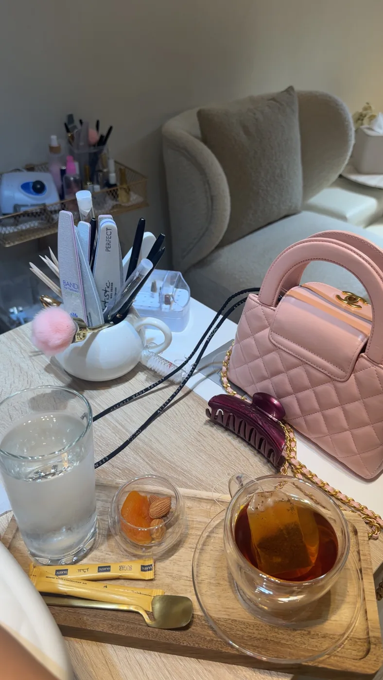 Manicure station with nail files and tools beside tea and water on a wooden tray